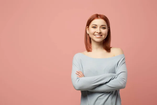 Mujer feliz en suéter gris con los brazos cruzados de pie en el estudio — Foto de Stock