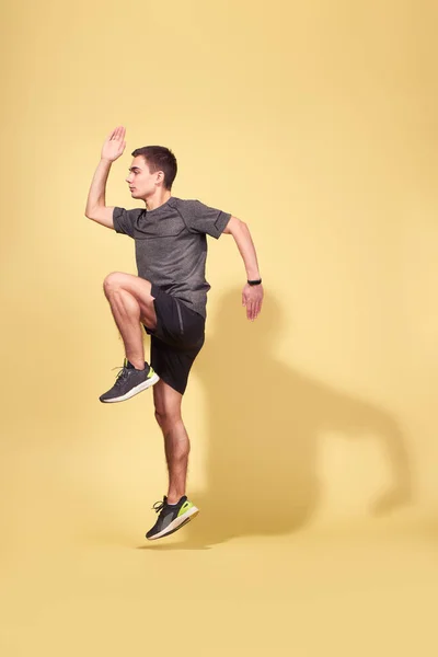 Vista lateral del atleta hombre corriendo en el estudio — Foto de Stock