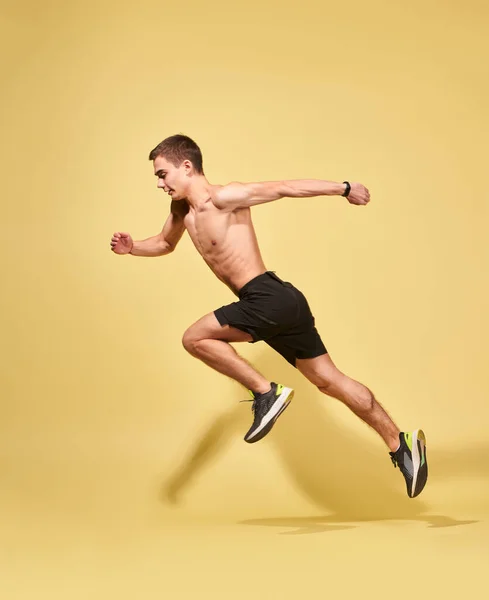 Side view of sportsman running in studio — Stock Photo, Image