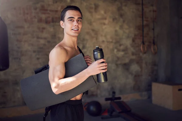 Sportman met tapijt en fles op achtergrond van een wazige bakstenen muur — Stockfoto