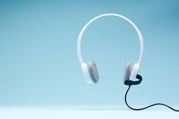 Headphones with microphone isolated on blank blue background — Stock Photo, Image