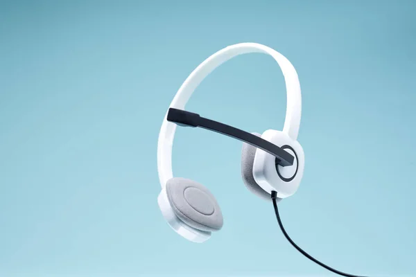 Auriculares blancos con micrófono negro aislado sobre fondo azul en blanco . —  Fotos de Stock