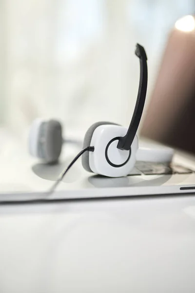 Gros plan des écouteurs blancs avec microphone sur fond flou . — Photo