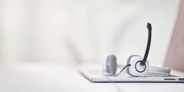 Laptop, mikrofonlu kulaklıklar masadaki odaklanmış arka plan..