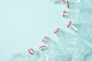 Mavi arka planda buruşmuş plastik şişeler