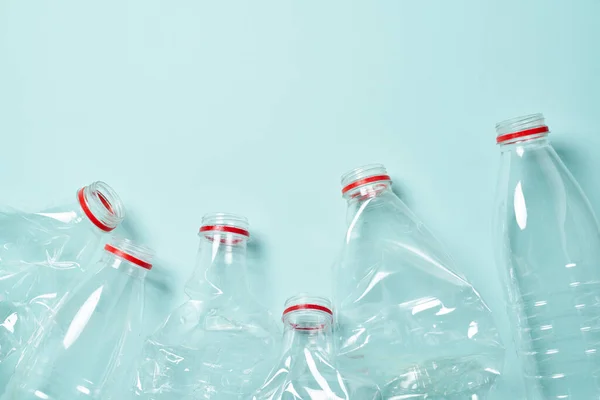 Prázdné zmačkané plastové láhve na modrém pozadí — Stock fotografie