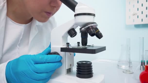 Kadın tıp araştırmacısı mikroskoptan bakıyor.. — Stok video