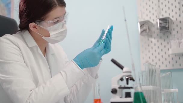 Doctora analizando líquido en probeta. Concepto de ciencia, biotecnología, salud y química . — Vídeo de stock