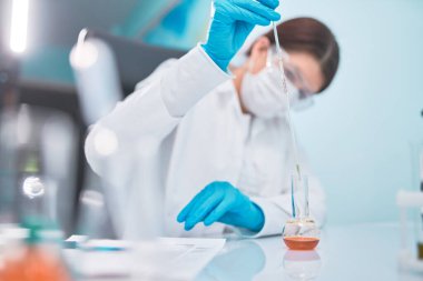 Pipet ve mataralı kadın laboratuvar teknisyeni, geçmişi bulanık..