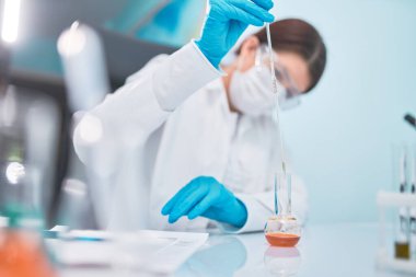 Pipet ve mataralı kadın laboratuvar teknisyeni, geçmişi bulanık..