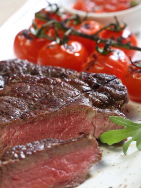 İştah açıcı sığır eti hissesini ve pişmiş domates