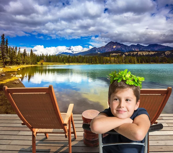 Garçon assis sur la chaise sur la rive du lac — Photo