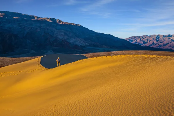 Photographe marchant dans les dunes de sable — Photo