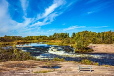 ahşap Bank Winnipeg River shore üzerinde 