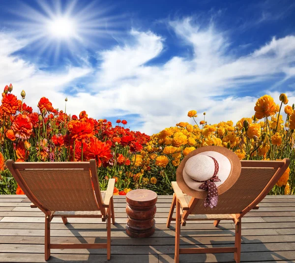 Straw hat hanging on a deck chair — Stock Photo, Image