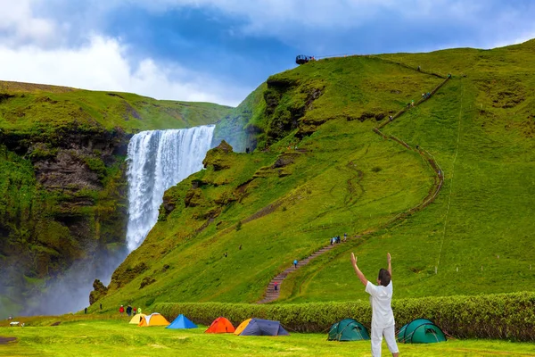 Elderly woman shocked by the beauty of the waterfall — Stock Photo, Image