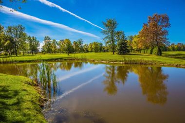 Sonbahar yaprakları küçük gölde yansıyan