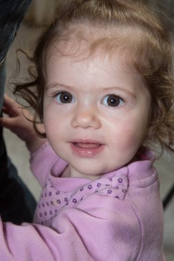 Küçük kız kameraya bakıyor.