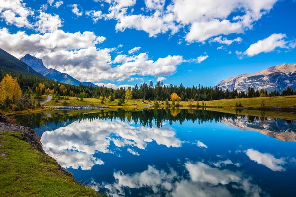 Nuvens refletidas na água lisa do lago — Fotografia de Stock