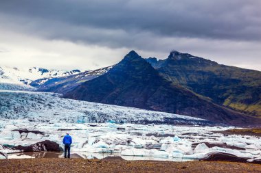 Bir yaz günbatımı kiriş içinde görkemli buzul İzlanda Vatnajokull. Aşırı Kuzey turizm kavramı. yalnız turist ICES hareketi izler