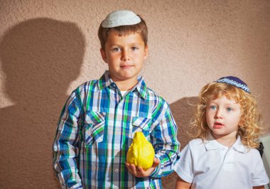  Sukkot İsrail. Kafatası-kapaklar iki güzel Yahudi çocuğu. Kardeş Shan bir ritüel meyve - Etrog tutar.