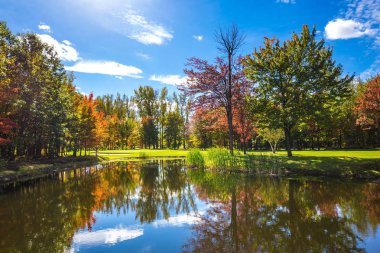  Park fantastik güzellik. Golf Kulübü Bromont, Fransızca Kanada giden yolda. Golf Turizmi kavramı. Kırmızı, turuncu ve sarı yapraklar Gölü nün su temizlemek için yansıtılır