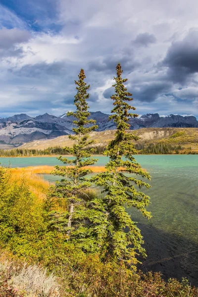 Aktif ve ekolojik turizm kavramı. Kayalar ve bulutlar uçan altında göl. Kanada kayalık dağlarında bulutlu. Hint yaz 