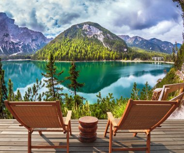 İki rahat ahşap şezlonglar gölün kıyısında. Yürüyüş ve eko-turizm kavramı. Çevredeki dağlar ve orman su yansıtır 