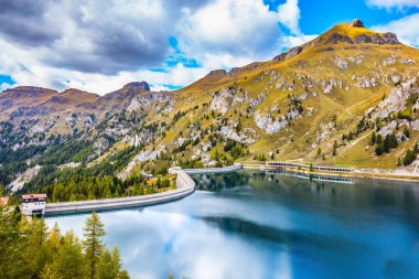 Sonbahar günü. Bulutlar pürüzsüz soğuk suda yansıtılır. buzul Gölü Lago di Fedaia Dolomites içinde. Ekolojik ve aşırı turizm kavramı