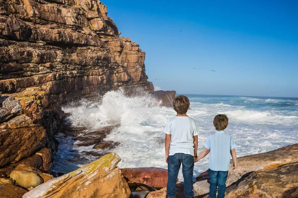 Two boys standing  on Cape of Good Hope - the south-western point of Africa. The concept of active tourism and recreation. Travel to South Africa.