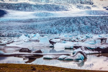 Günbatımı buzul aydınlatır. Buzul su buz Lagoon Jokulsarlon sağlar. Aşırı Kuzey turizm kavramı