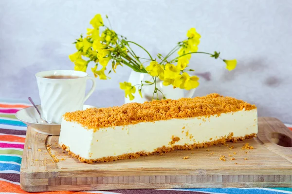 Papatya ve porselen fincan sıcak çay ile vazo. Profesyonel fırını. Beyaz peynirli kek, tatlı kırıntıları ile serpilir