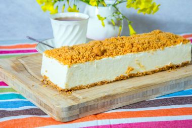 Ahşap tahta üzerinde turuncu tatlı kırıntıları beyaz peynirli kek serpilir