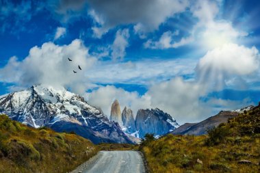 Çakıl yol Torres del Paine Milli Parkı'nda. Dağlar ve kayalar kar ve buz ile kaplıdır. Yaz aylarında güney Şili. Aktif ve aşırı turizm kavramı
