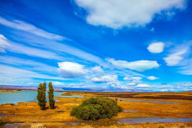 Patagonya Pampaları. Güçlü rüzgar bulutları taşır. Sığ gölleri ve sarı otları olan düz bir düzlük. Aktif ve egzotik turizm kavramı 