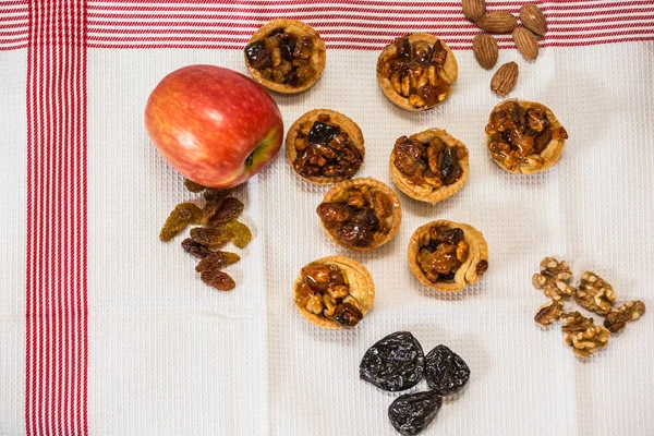 Magnificent portioned tartlet cakes with filling nuts and dried fruits. Professional baking