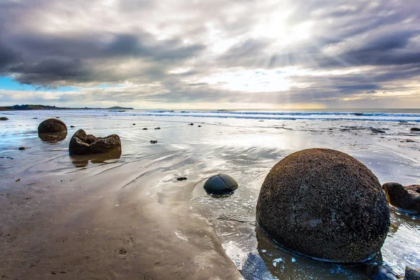 Валуны Моераки на песчаном пляже — стоковое фото