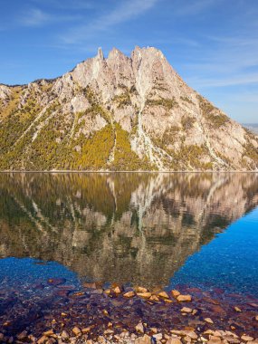  Göl keskin tepeleri ve kayaları yansıtır.