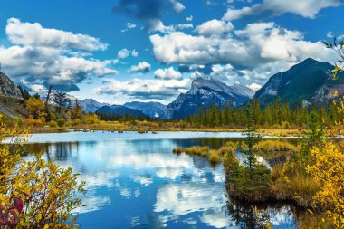 Bereketli kümülüs bulutları gölün yumuşak suyuna yansımaktadır. Vermilion Gölü 'nde sıcak bir sonbahar günü. Ekolojik, fotografik ve aktif turizm kavramı