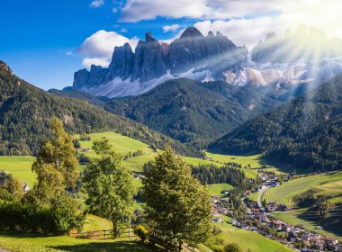  Alp çayırlarında eko-turizm kavramı. Güzel bir sonbahar günü. Güneş, Dolomitlerdeki kırsal çiftliği ve yeşil alp vadisini aydınlatıyor.