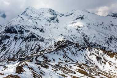 Dağ yamacındaki kar erimeye başladı. Büyük Avusturya Alpleri. Dağ yılanının baş döndürücü dönüşleri. Grossglocknerstrasse. Aktif, ekolojik ve fotoğraf turizmi kavramı