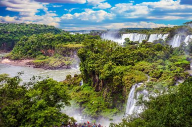  Travel to Argentina. Powerful jets of the world famous waterfalls Iguazu. Picturesque basaltic ledges form the waterfalls. The concept of exotic and active tourism clipart