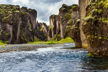 Bulutlu bir yaz günü. İzlanda 'nın en güzel ve gizemli kanyonu Fyadrarglyufur. Buzul suyu olan nehir tuhaf uçurumlar arasında akar. Aktif, eko ve fotoğraf turizmi kavramı