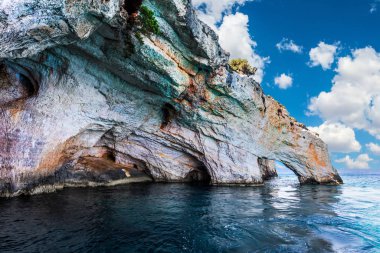 Yunanistan, Zakynthos adası. Parlak mavi deniz suyu kıyı kayalıklarını yansıtır. Yat adanın kayalık kıyıları boyunca yelken açar. Deniz, aktif ve tatil beldesi konsepti