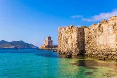 Üç katmanlı muhteşem gözetleme kulesi denizde uzun bir pelerin üzerine inşa edilmiştir. Deniz sürüsü güzel gök mavisi renginde. Yunan Yarımadası Peloponese 'deki Venedik kalesi Methoni. Aktif, fotoğraf ve tarihi turizm kavramı
