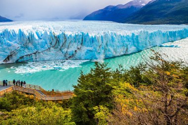 Patagonya 'daki Arjantin Gölü üzerindeki devasa Buzul Perito Moreno. Turistler için geniş ve rahat bir gözlem güvertesi. Aktif ve ekolojik turizm kavramı