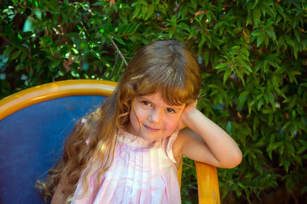 Menina encantadora descansando em uma cadeira — Fotografia de Stock