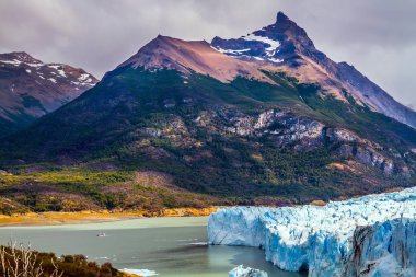 Arjantin Gölü 'ndeki muhteşem buzul Perito Moreno, Patagonya. Bulutlar ve buzullar yansıyan güneş ışığıyla parlıyor. Egzotik ve aşırı turnuva konsepti