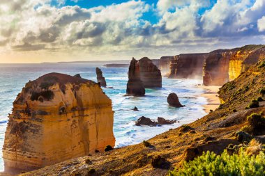 Egzotik, aktif ve fotoğraf turizmi kavramı. Gün batımında On İki Havarinin Kayaları. Güçlü Pasifik sörfü kıyıda bozuluyor. Avustralya 'nın görkemli kıyıları
