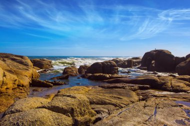 Coastline, beach and stones on the Atlantic coast. The concept of exotic, active and photo tourism. Fabulous port city Cape Town at the foot of Table Mountain 